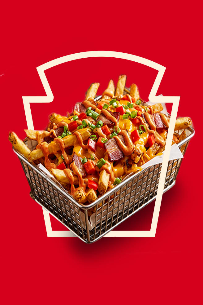 Loaded fries topped with bacon, peppers & Heinz Harissa Aioli, framed by the Heinz keystone.