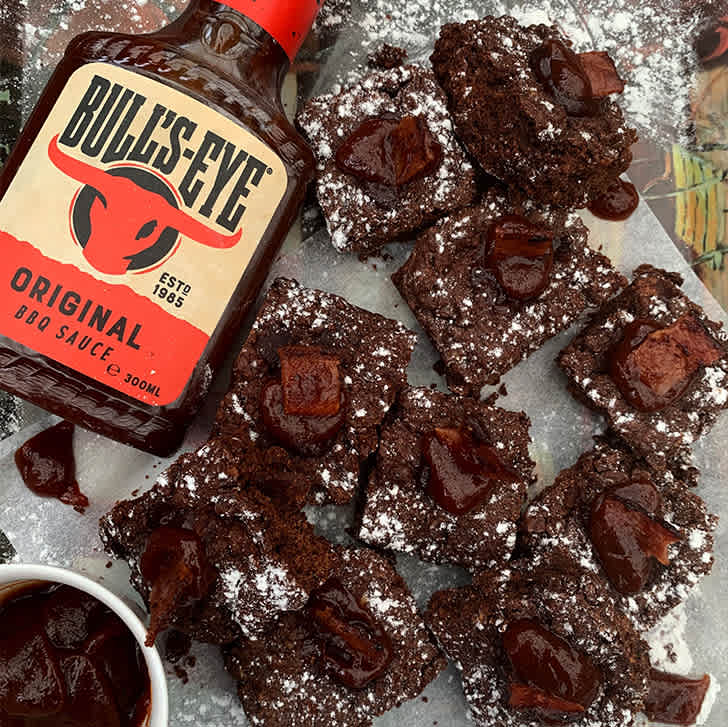 Dark chocolate brownies topped with crisp bacon pieces and a glossy BBQ sauce drizzle.