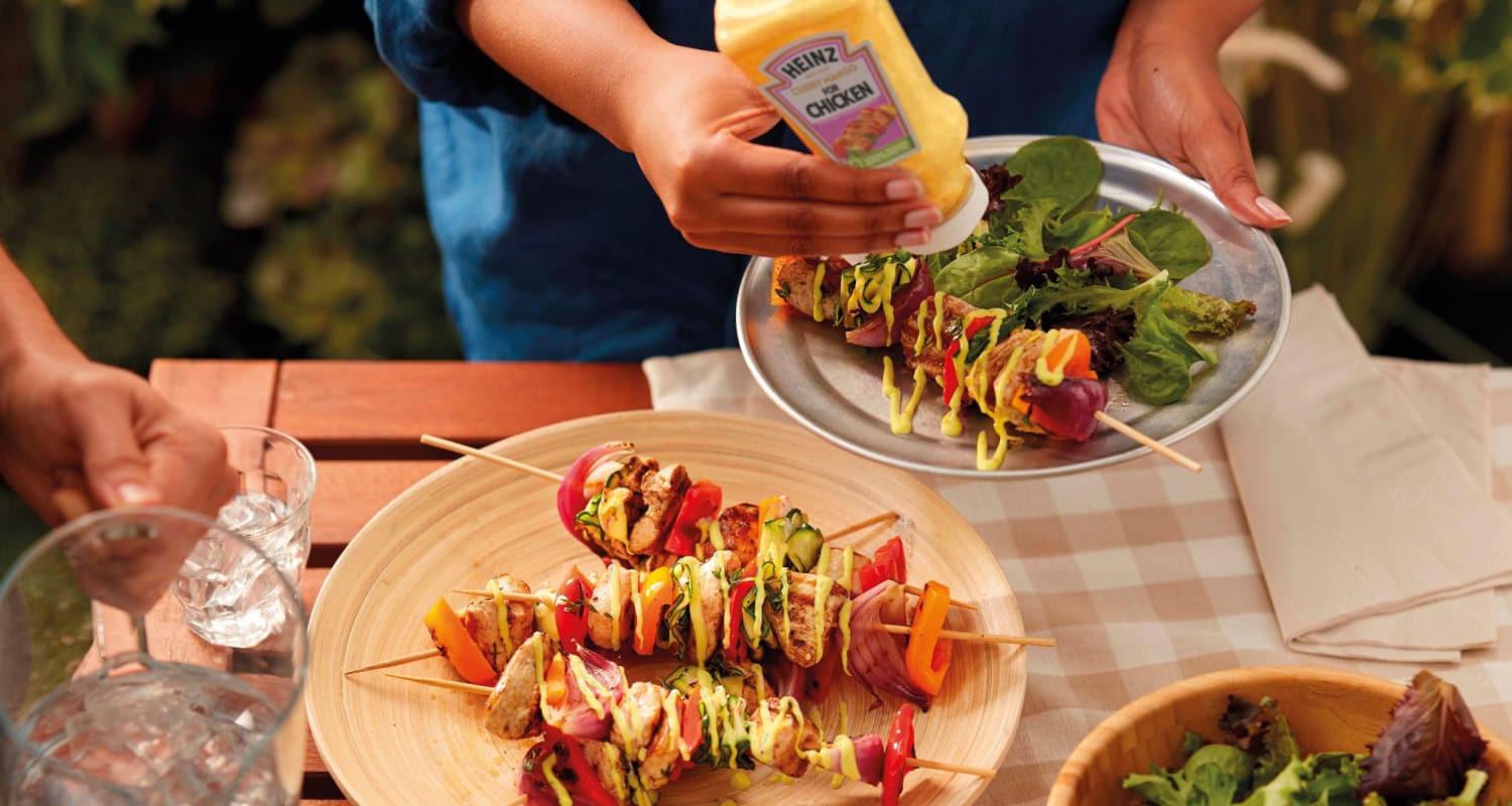 Gegrilde groente- en vleesspiesjes op een houten bord.