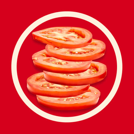 Six thin slices of ripe red tomato are arranged in a slightly offset stack on a vibrant red background, encircled by a contrasting off-white ring. The tomato slices' juicy interiors and seeds are visible. This image represents six servings.