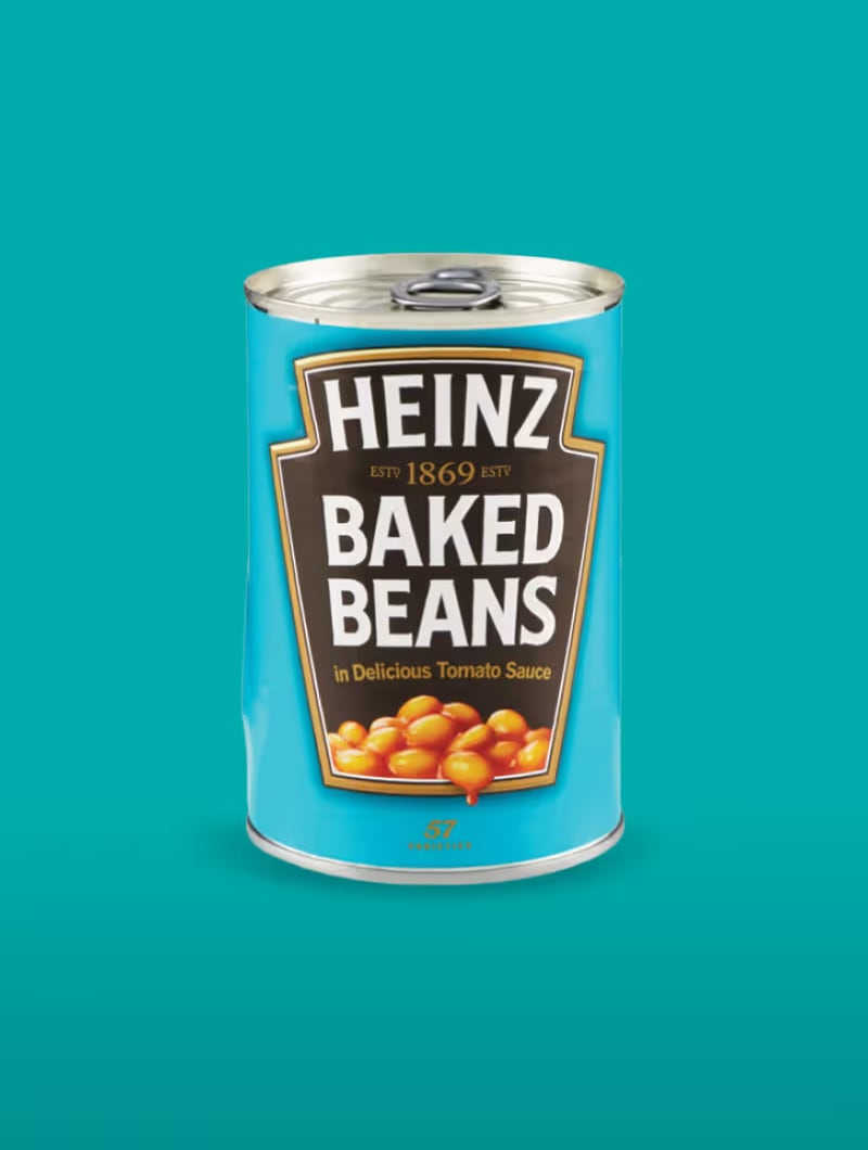 Plechovka Heinz Baked Beans s modrým obalem a obrázkem fazolí, na tyrkysovém pozadí.