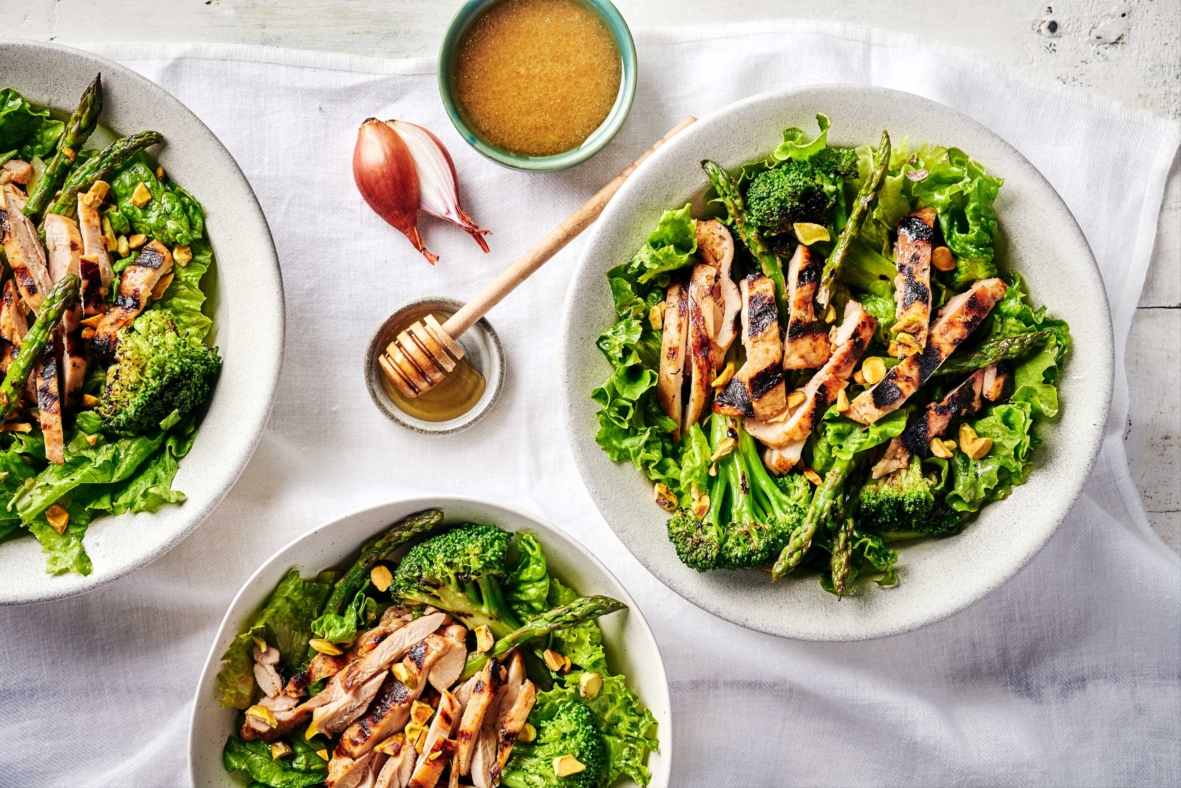 Salade de poulet et légumes avec poulet grillé, brocolini, asperges, laitue et pistaches, arrosée de vinaigrette et marinade Pure J.L. KRAFT miel et échalotes.