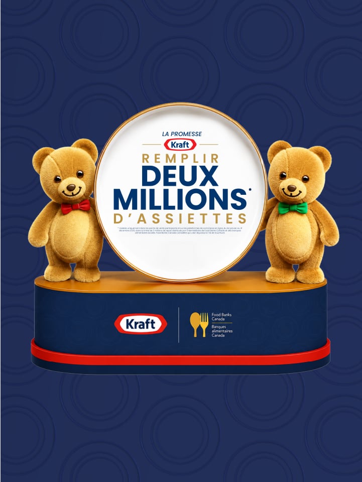 Deux oursons Kraft debout près d'une assiette avec le texte 'Remplir deux millions d'assiettes'. Fond bleu.