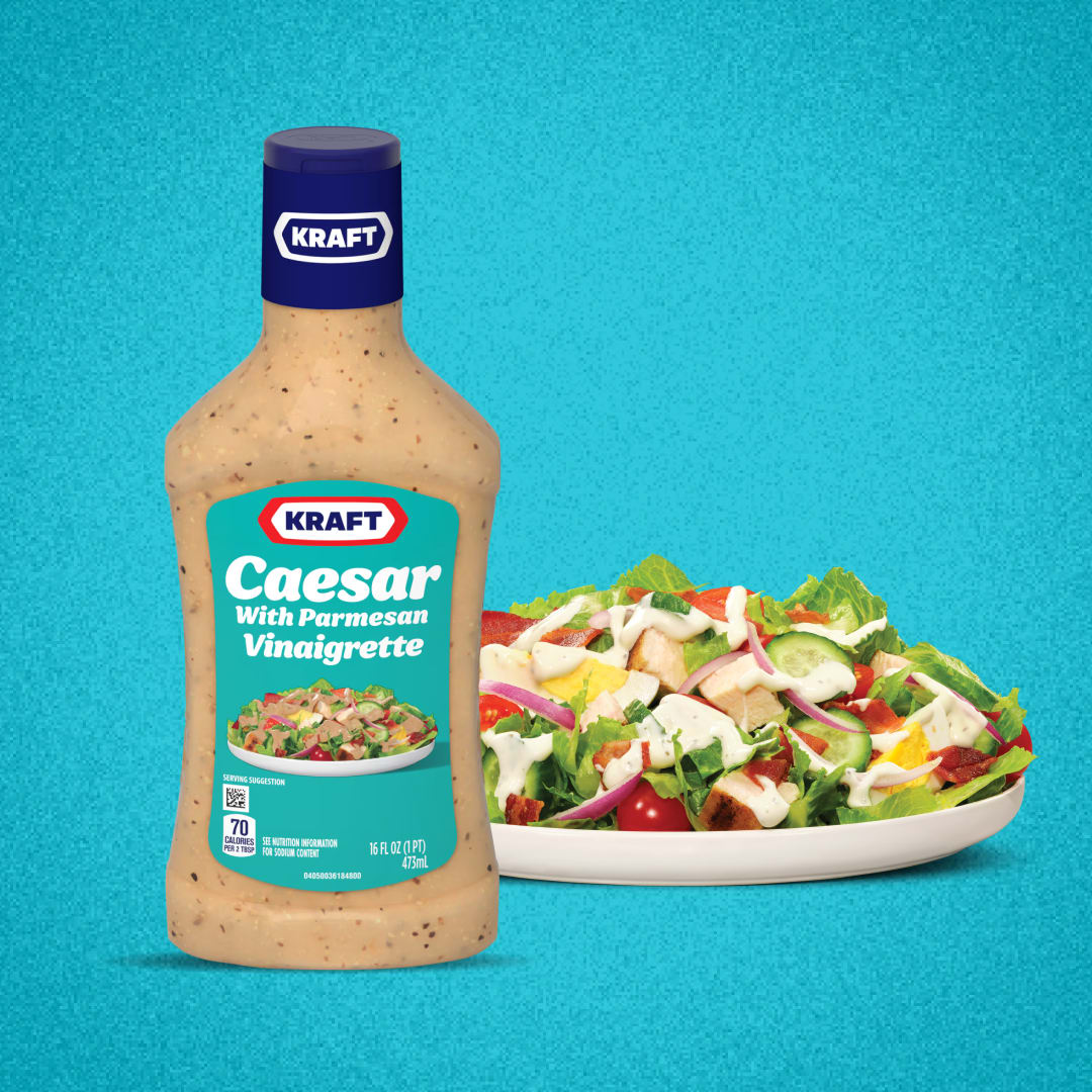 Kraft Caesar with Parmesan Vinaigrette bottle next to a salad.