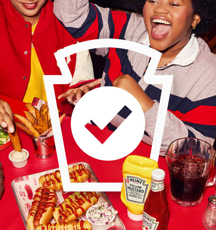 People enjoying hot dogs, fries, and coleslaw with Heinz condiments on a red table, with a Heinz keystone and checkmark.
