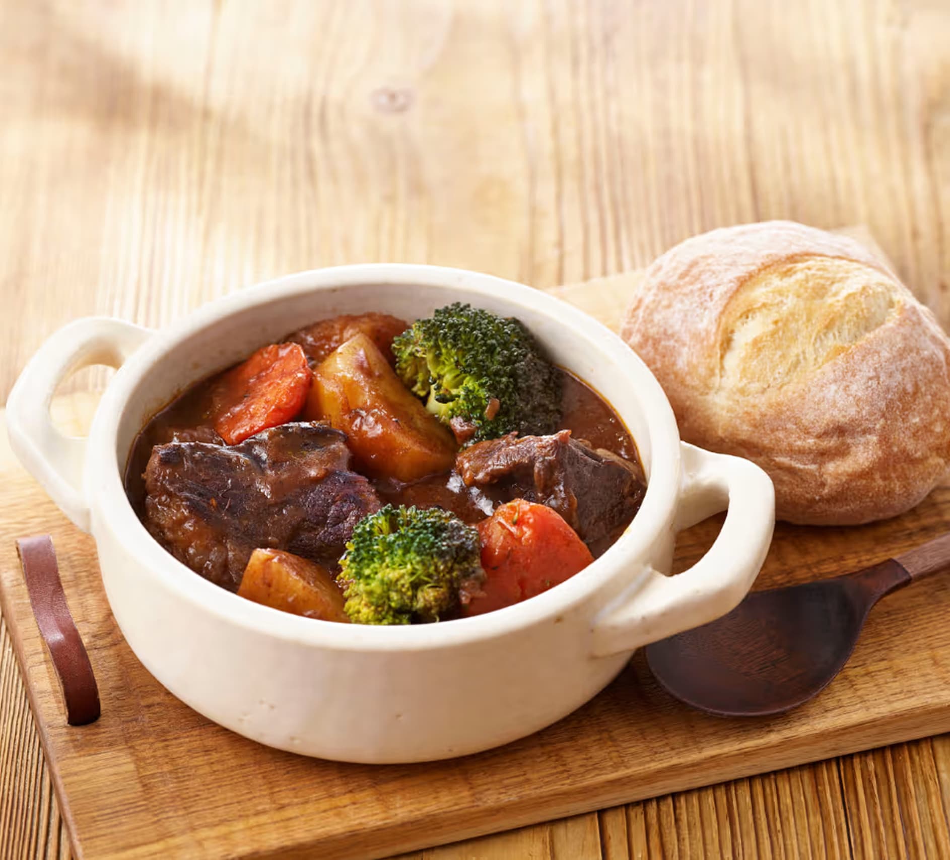 パン付きのボウルに入った野菜入りビーフシチュー