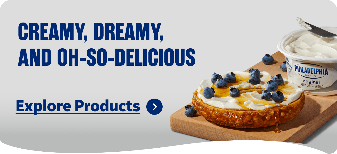 Philadelphia Original Cream Cheese spread on a bagel with blueberries and honey.