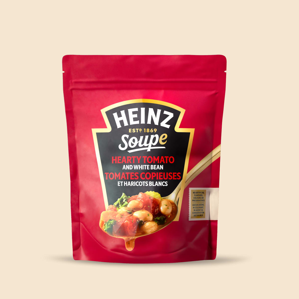 Red pouch of Heinz Hearty Tomato and White Bean soup with a spoonful of tomato soup.