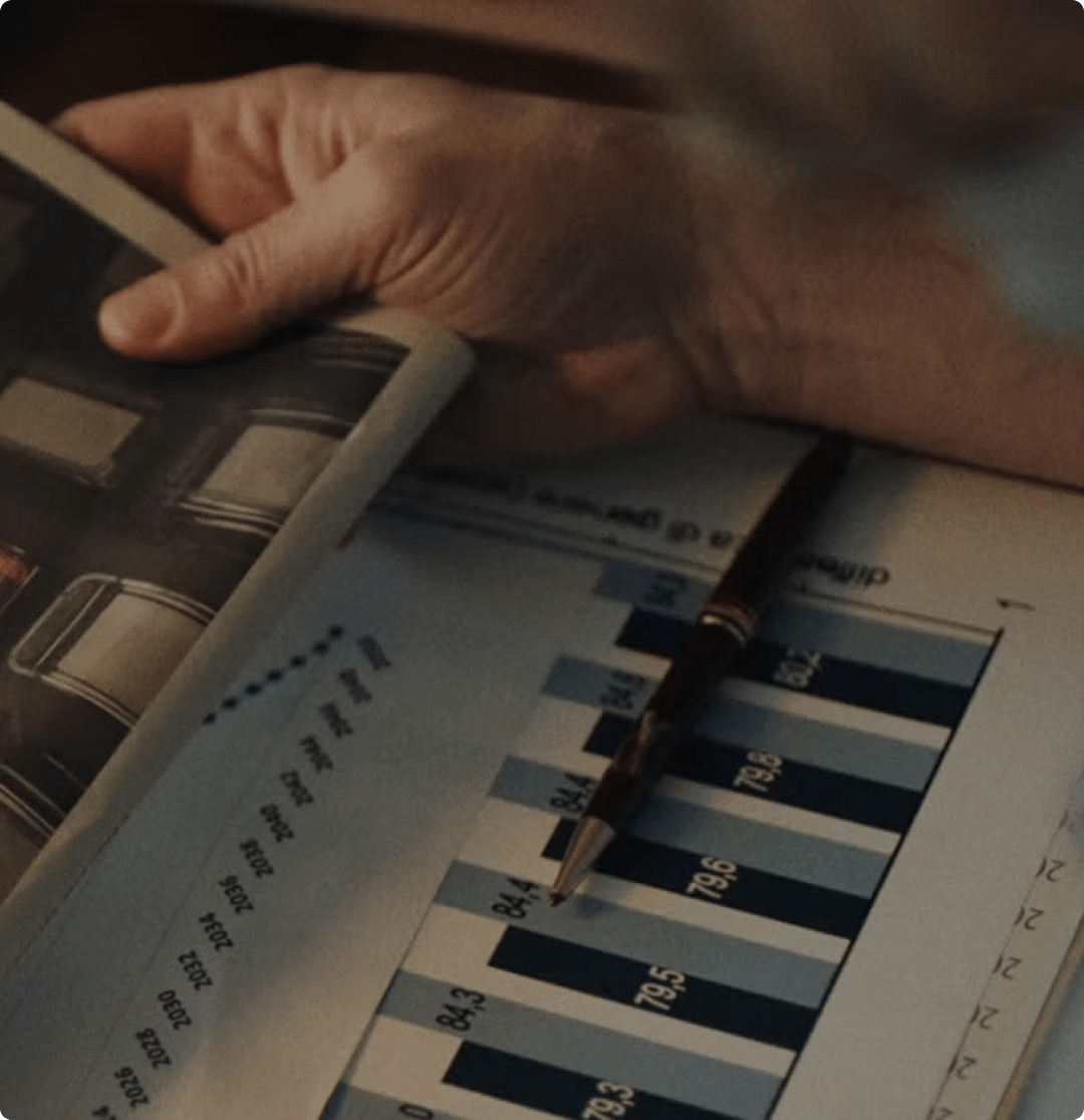 Mano con penna su grafico finanziario.