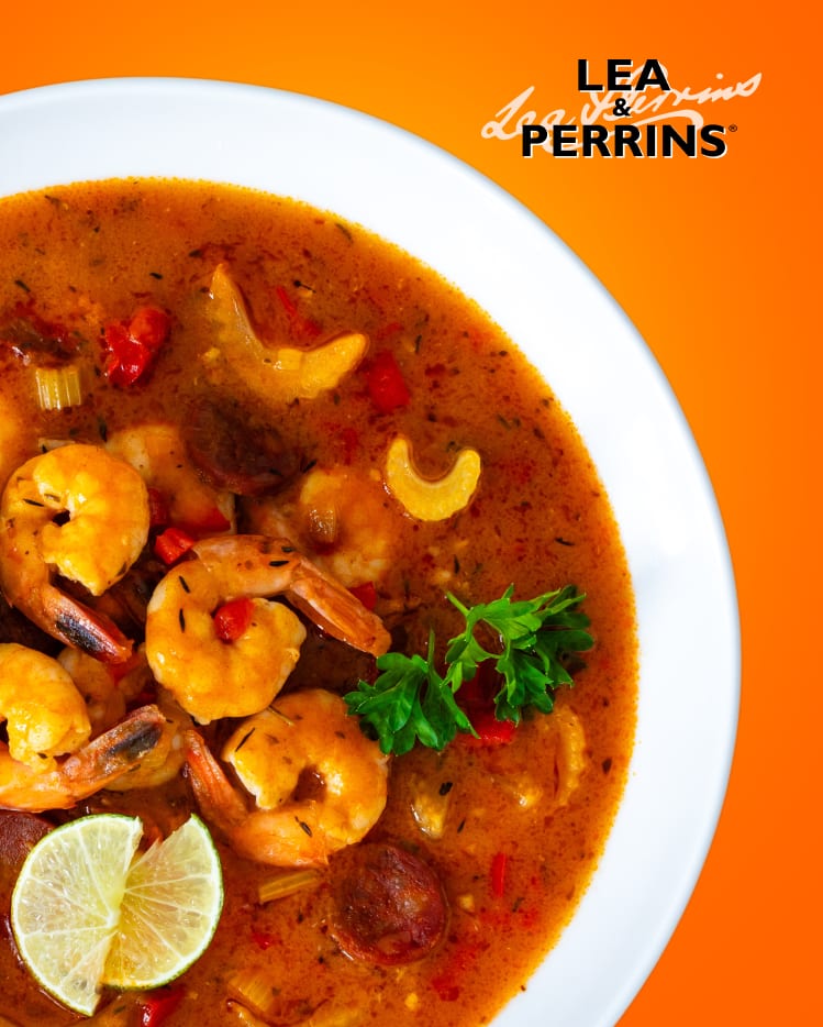 A prawn and sausage soup on large white bowl.