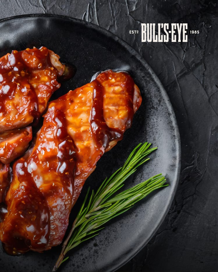 A plate of savoury ribs slathered with Bull's-Eye BBQ Sauce.