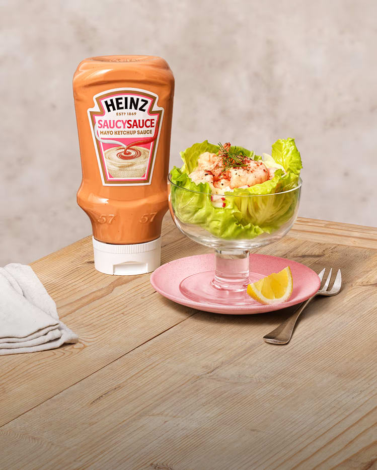A classic prawn cocktail served in a glass over lettuce, accompanied by Heinz Saucy Sauce.