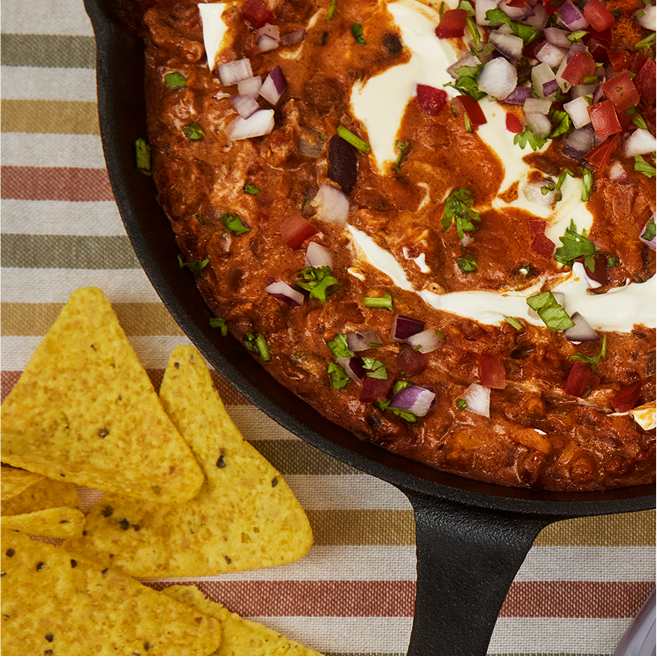 A photo of a skillet with chili and a drizzle of Philadelphia Cream Cheese