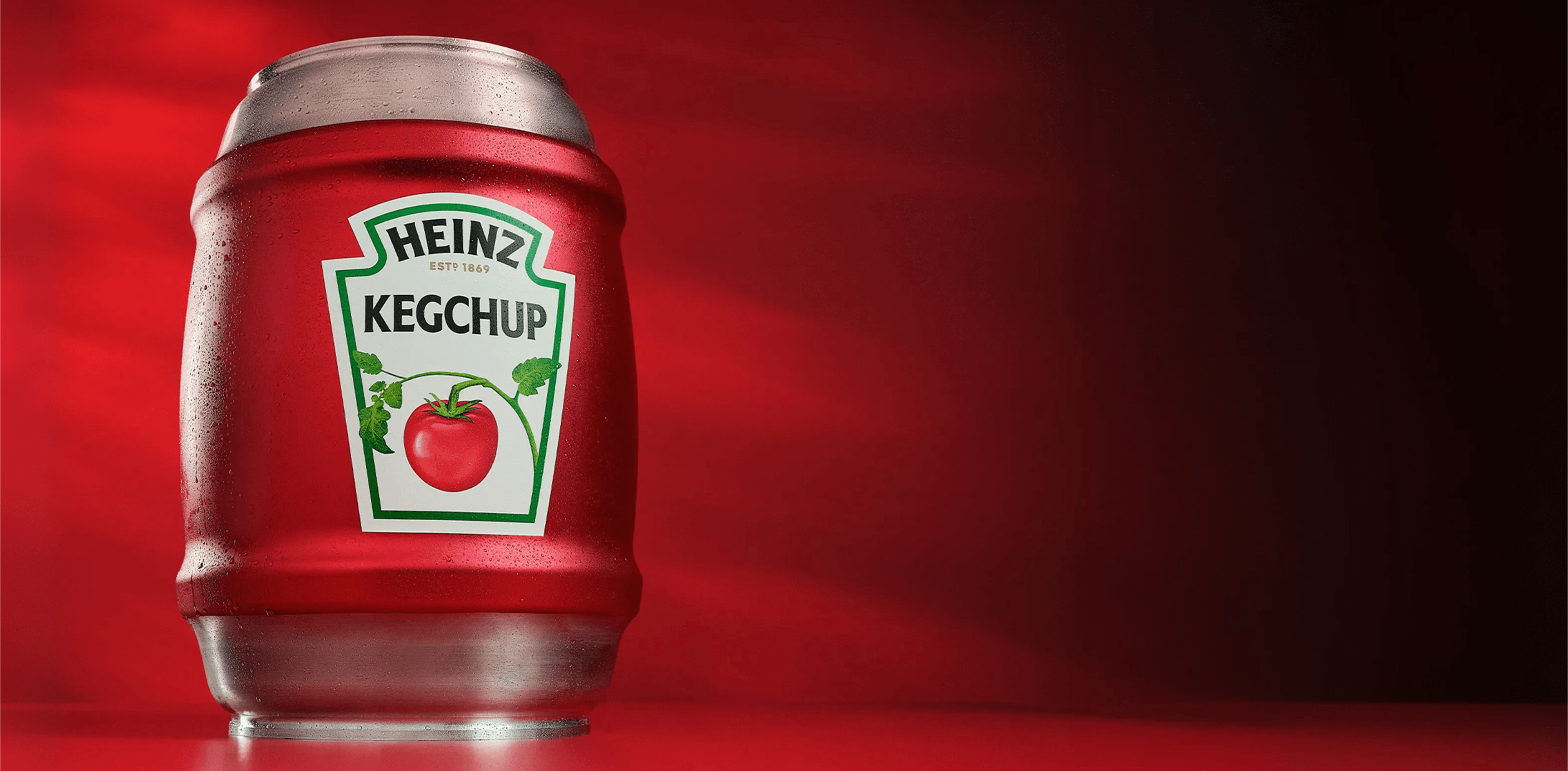 一个红色金属桶，上面贴有亨氏标签，写着“KEGCHUP”，并配有番茄图案，背景为红色。