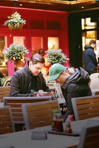 Two people sitting at an outdoor restaurant.
