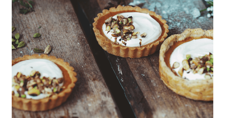 Tartlets with cream and nuts on a wooden surface