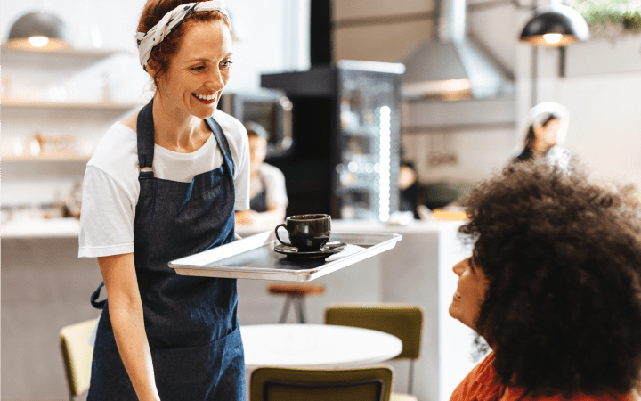 A friendly waitress serving coffee to a customer at a restaurant