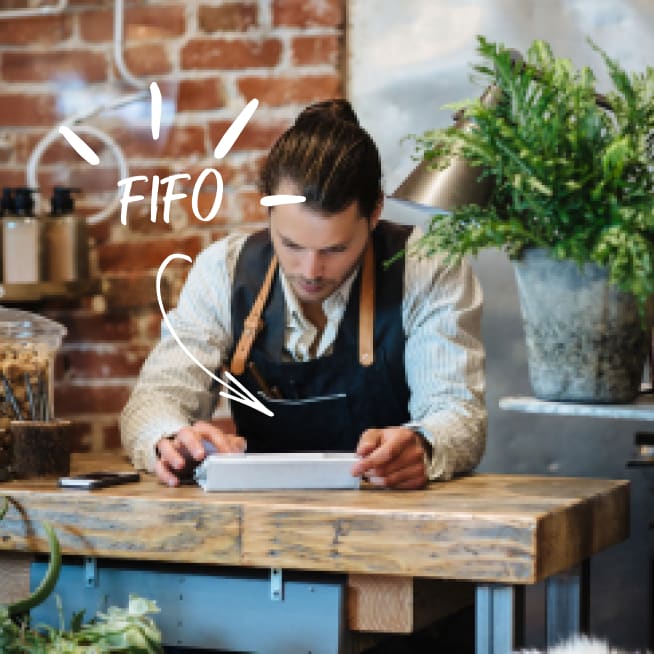 Restaurant owner sitting down at a table using a digital tablet