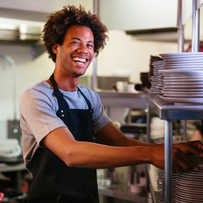Waiter taking plate in kitchen