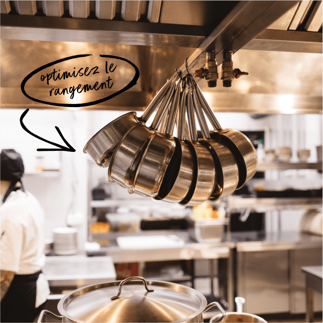 Des casseroles suspendues dans une cuisine de restaurant