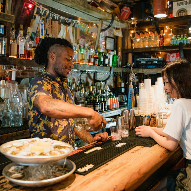 Bartender preparing a cocktail for a customer at a bar