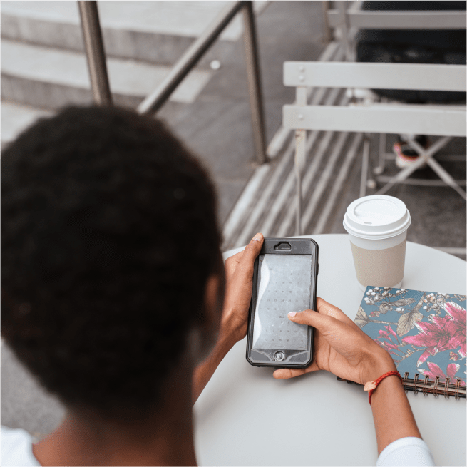Une femme utilisant un téléphone cellulaire dans un café.