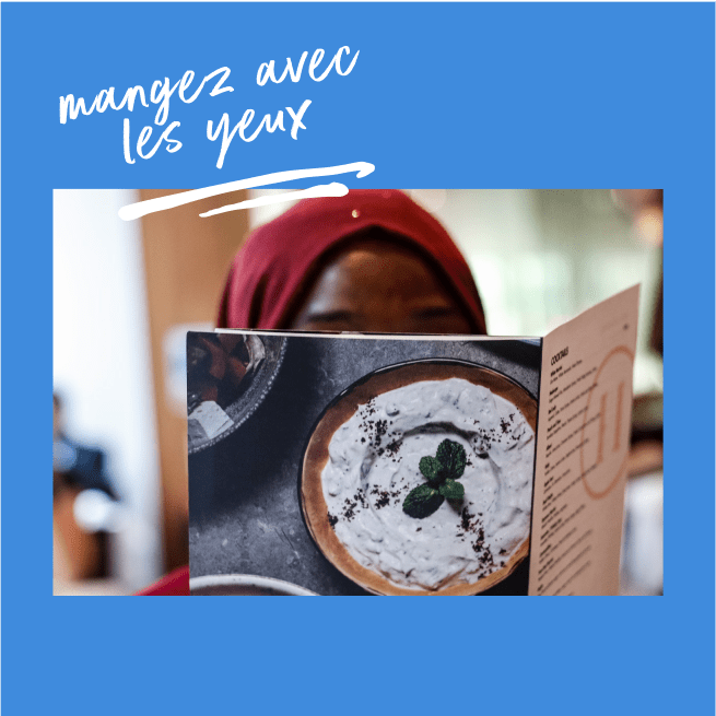 Une femme portant un hijab lit un menu présentant une photo de dessert.