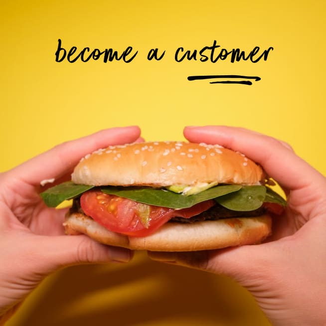 A person holding a burger with the phrase 'become a customer'