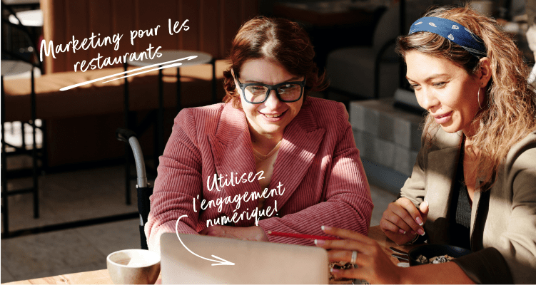Deux femmes travaillant sur un ordinateur portable à une table.