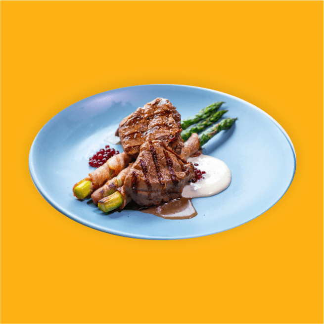 Grilled sirloin steak with asparagus and bacon on a blue plate.
