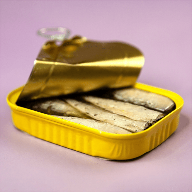 Une boîte jaune de sardines en conserve sur un fond violet.