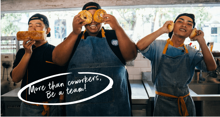 Three playful chefs showcasing bread and pastries.