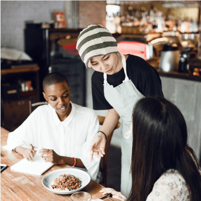 Une serveuse sert de la nourriture aux clients dans un restaurant.