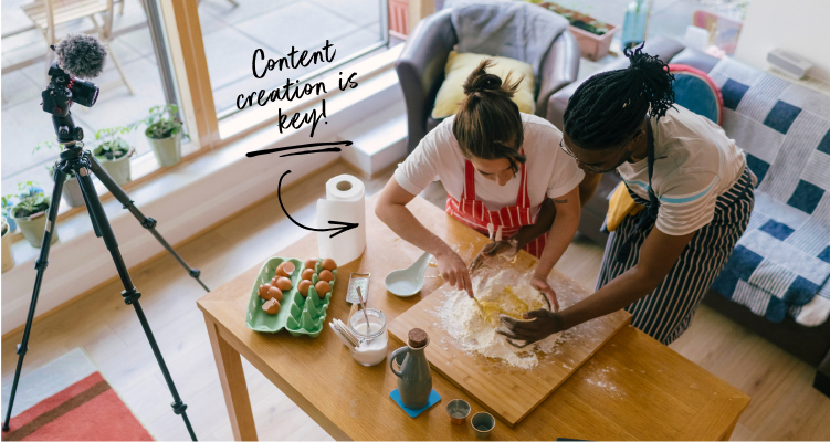 Two bakers make dough in front of a camera.