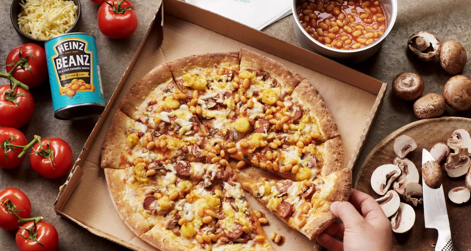 Pizza with beans, mushrooms, tomatoes, and a can of beans.