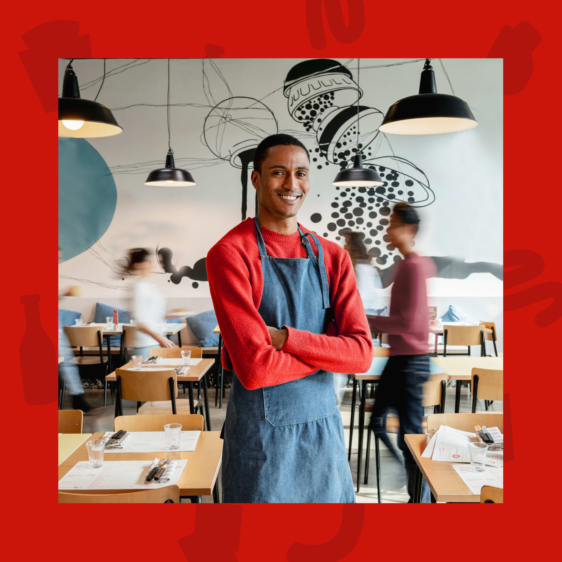 Un uomo sorridente che indossa un grembiule in un ristorante.