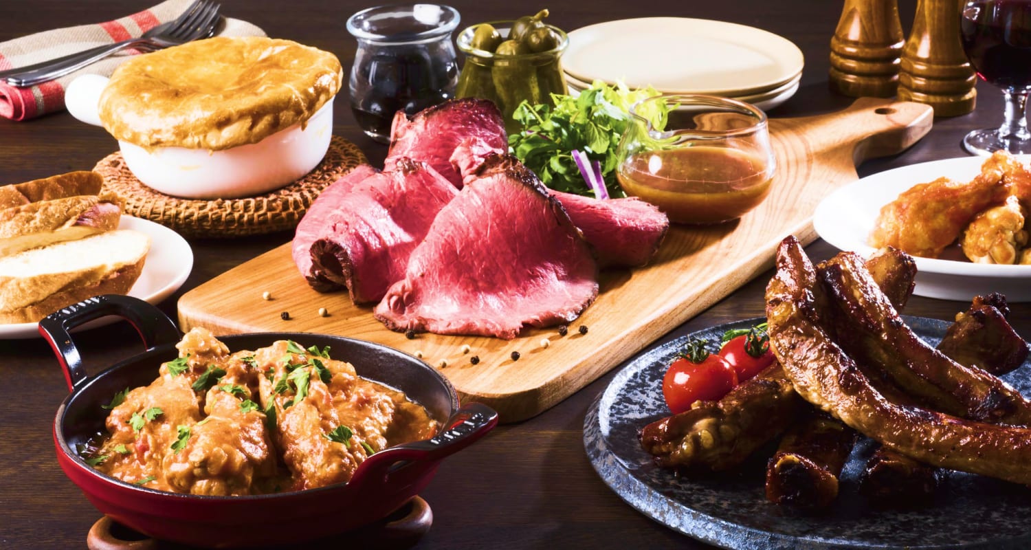 ローストビーフ、ポットパイ、様々なサイドディッシュをフィーチャーしたおいしい食事のクローズアップ。