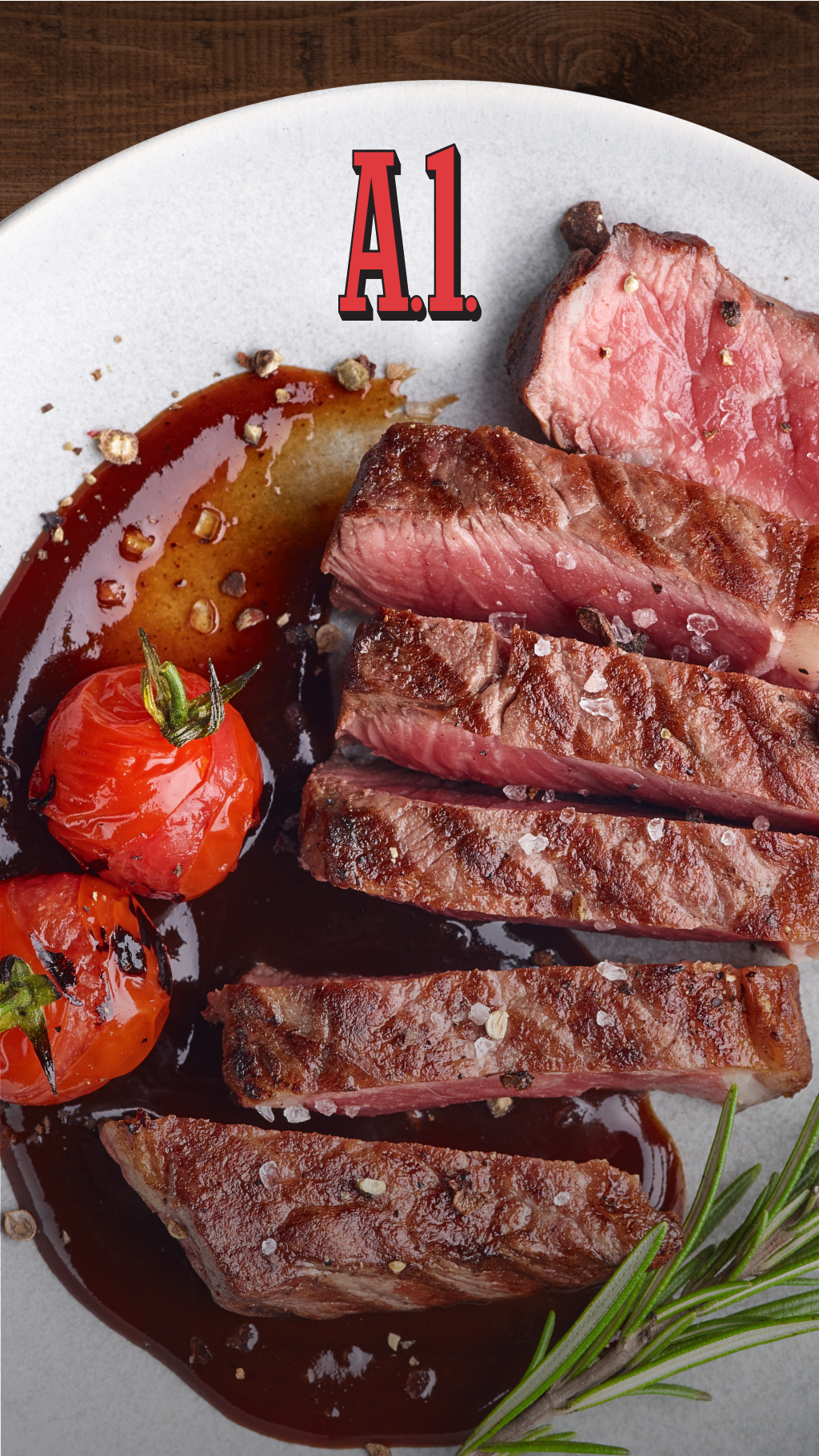 A steak cut in slices sits on a plate with the A1 logo along with cooked tomatoes, brown sauce and a sprig of rosemary