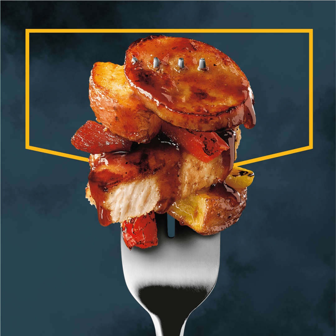 Fourchette avec aliments empilés: pommes de terre, viande, poivrons et sauce.