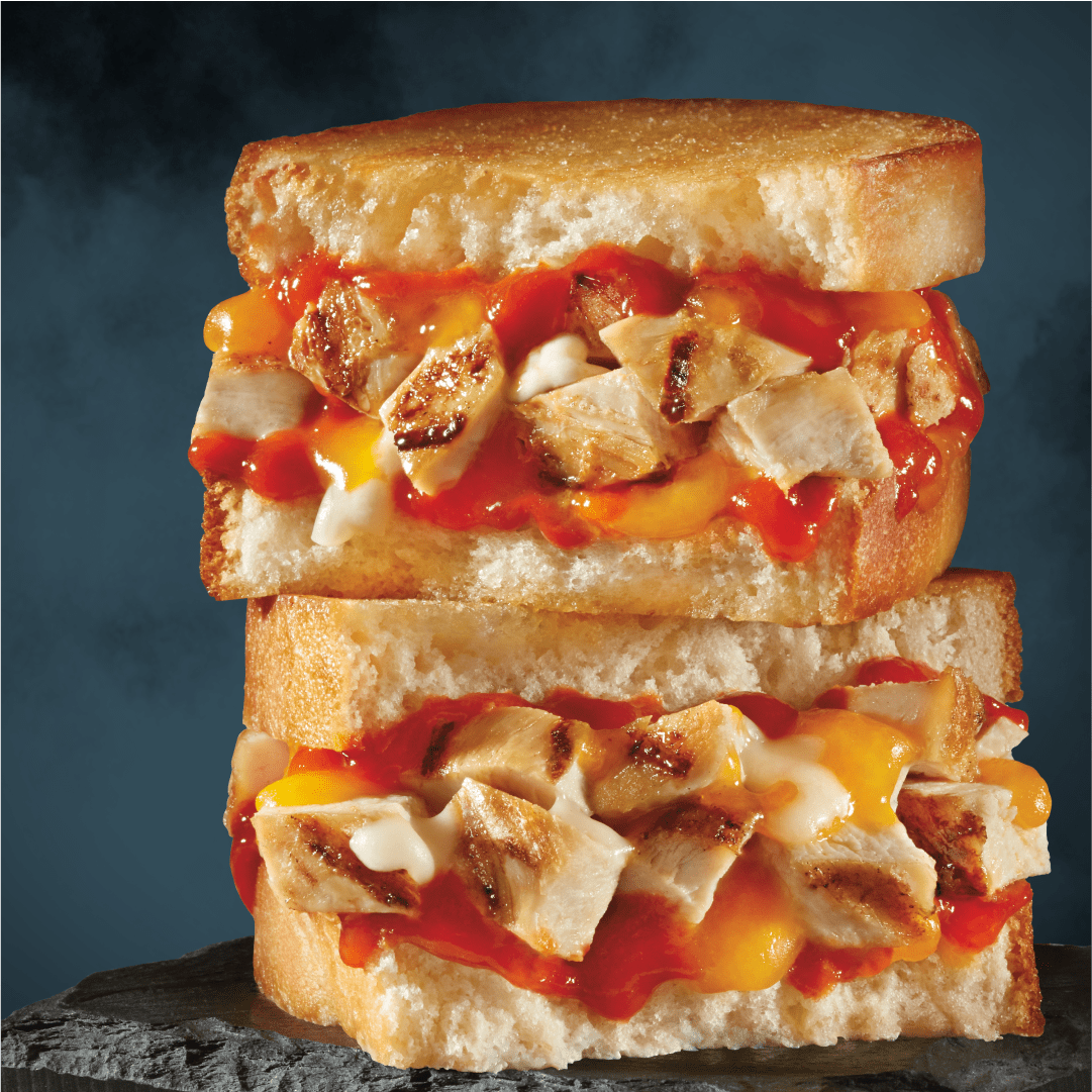 Pile de deux sandwichs au poulet avec sauce.