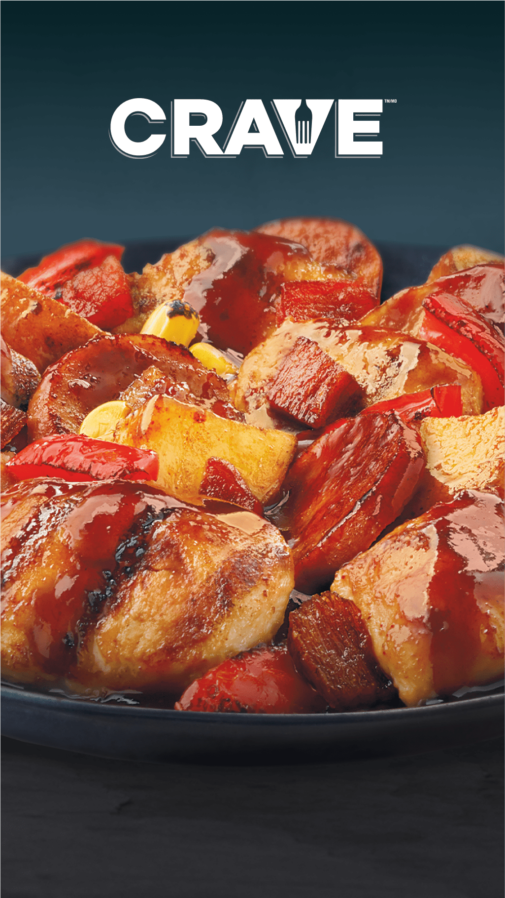 A plate of chicken pieces, potatoes, and red bell peppers with a glossy sauce.