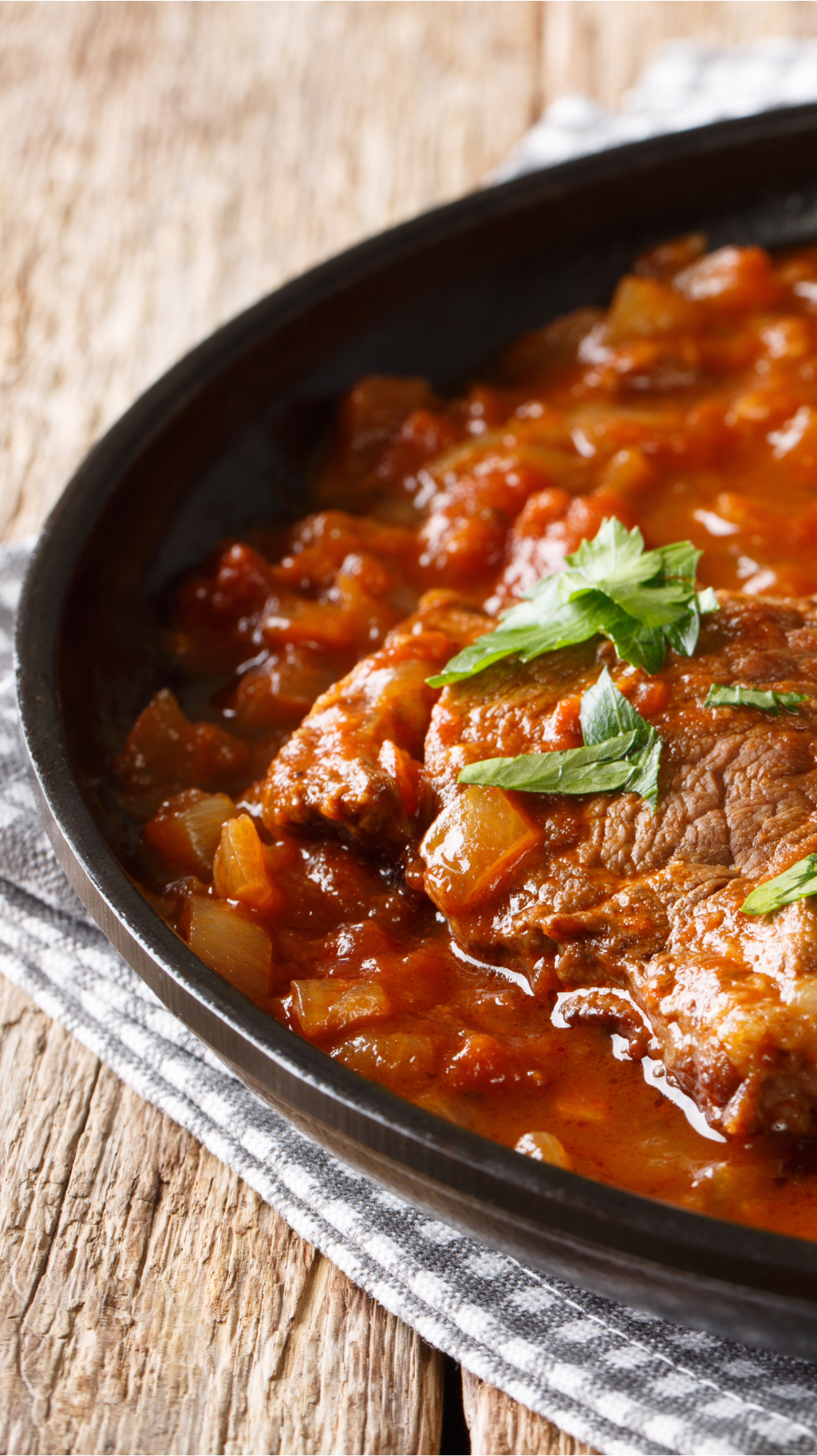 Boeuf braisé en sauce tomate, garni de persil.