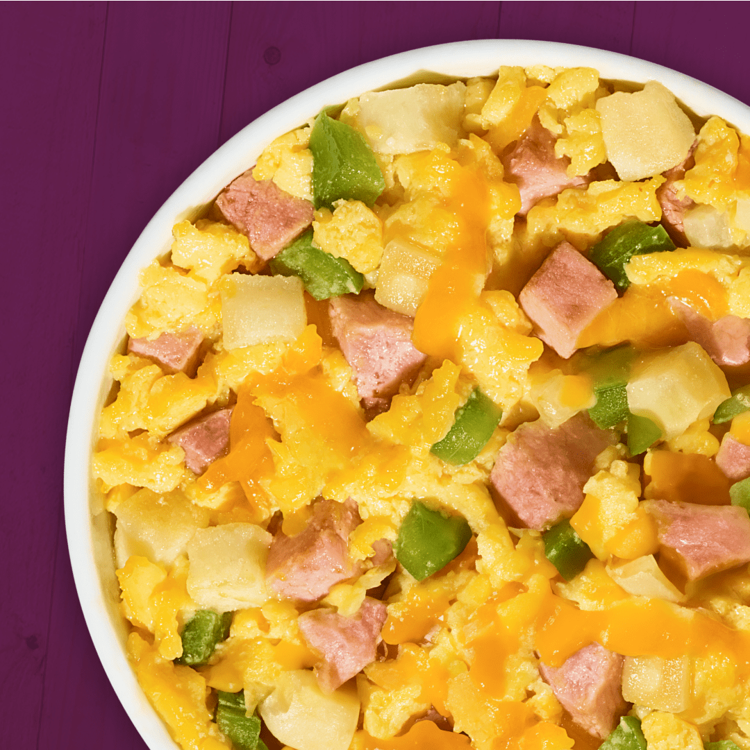 Breakfast casserole with eggs, ham, cheese, potatoes, and green peppers.