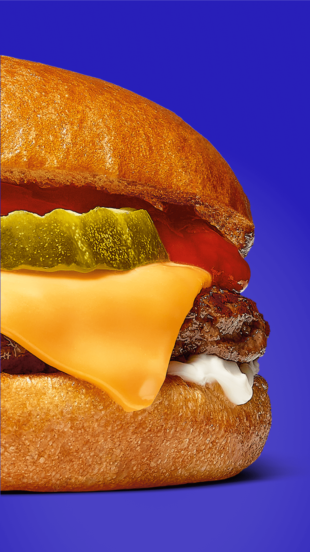 A burger with pickles, ketchup, Kraft Singles cheese, a patty, and mayo