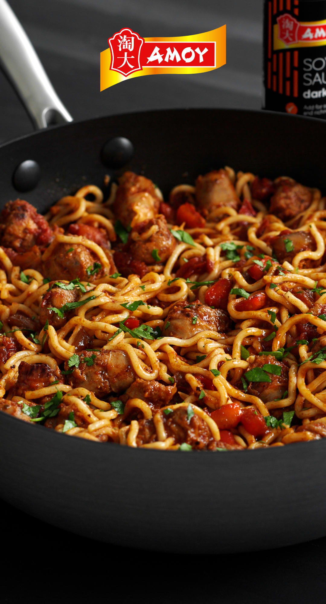 Noodles en gehaktballen in een pan. AMOY-logo.