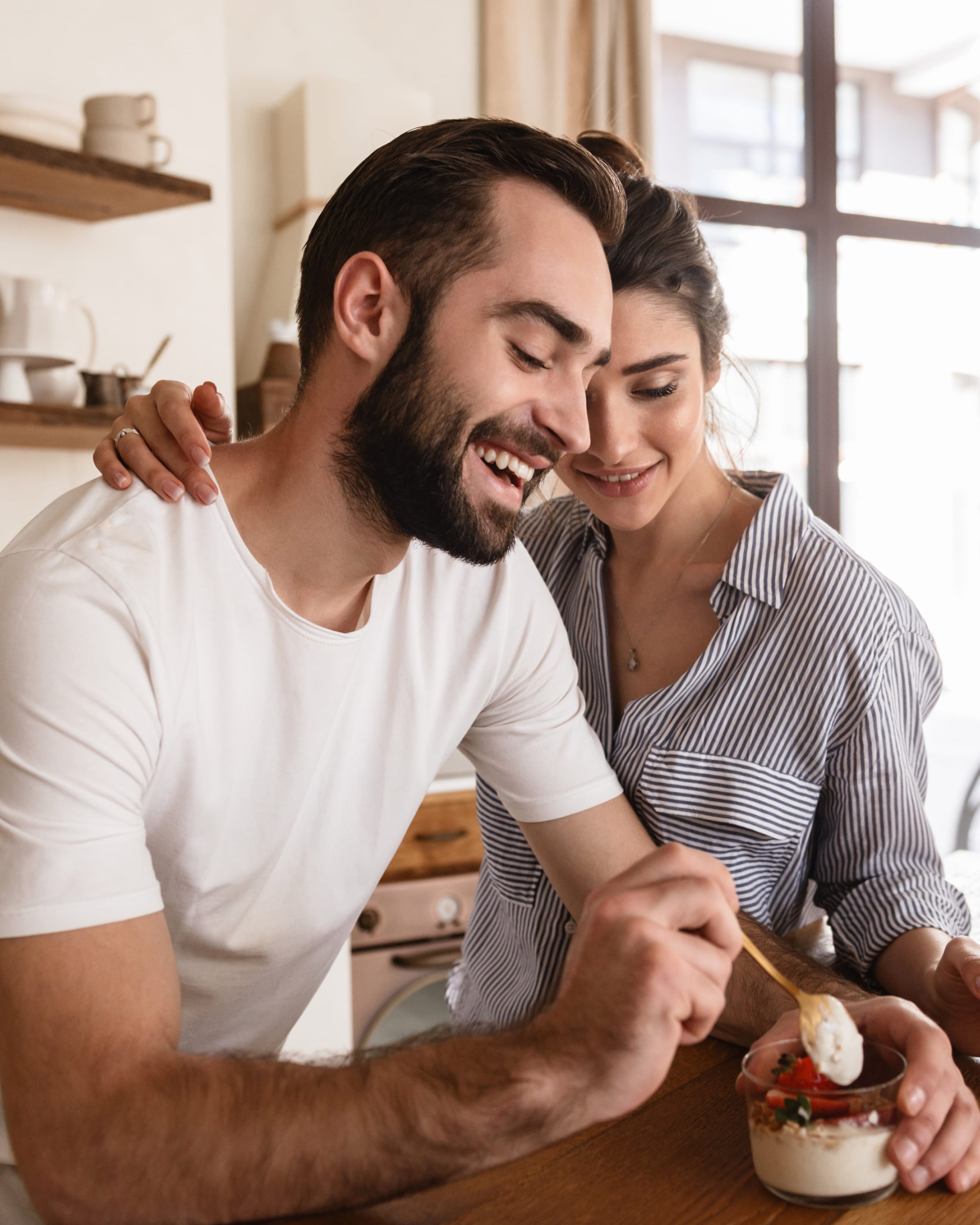 Een jong koppel dat ontbijtgranen eet in hun keuken.