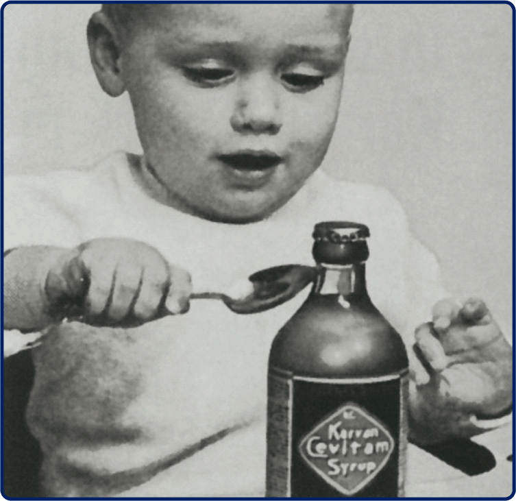 Een historische foto van een kind dat een lepel siroop eet.