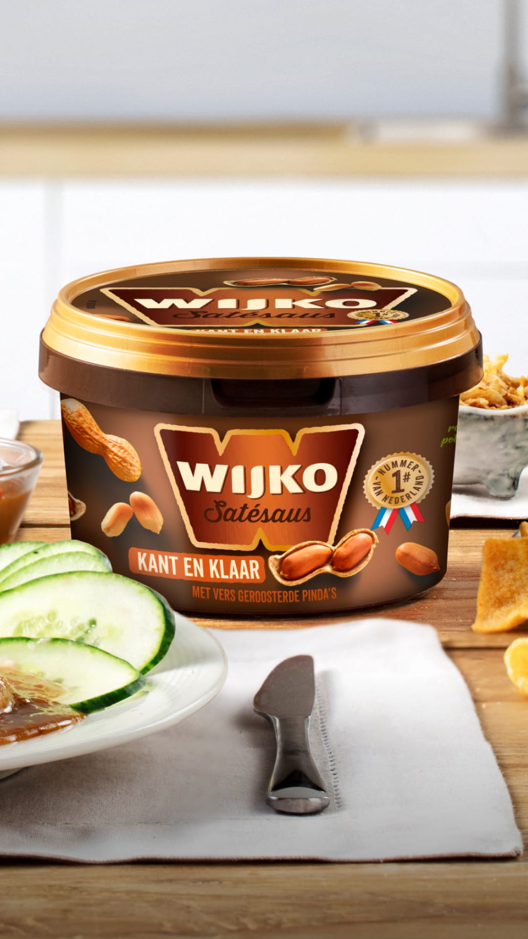 Afbeelding van een pot Wijkos Satésaus, omringd door gerechten bereid met de saus.