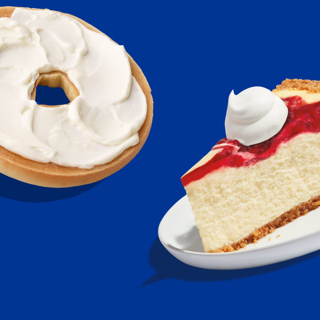 Un bagel avec du fromage à la crème et une pointe de gâteau au fromage sur fond bleu.