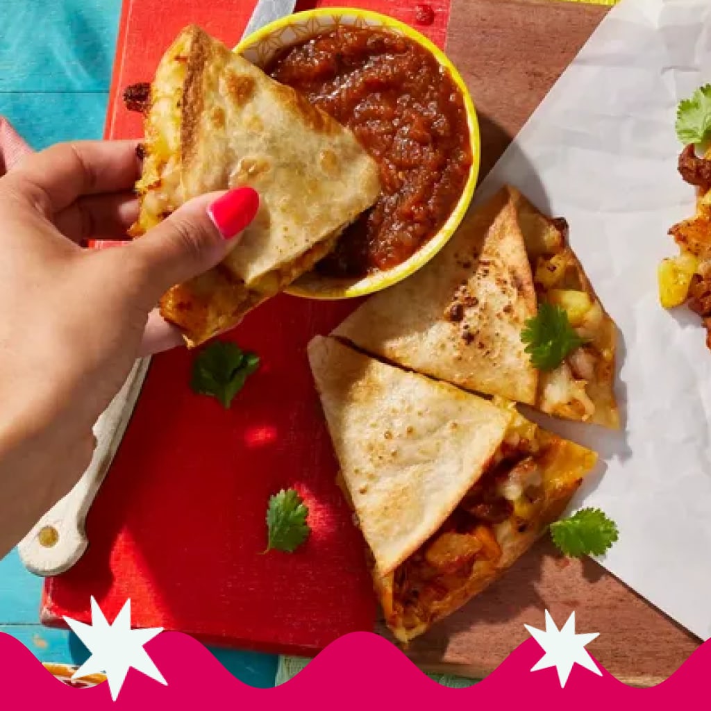 Image of quesadillas with salsa, a hand holds a piece.